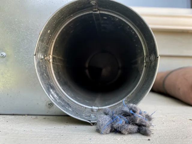 Poinciana Dryer Vent Cleaning technician using specialized equipment to clear severe dryer vent blockage in Poinciana